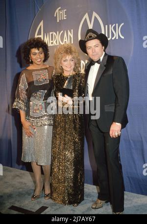 **FILE PHOTO** Mickey Gilley Has Passed Away.  Deniece Williams, Barbara Mandrell and Mickey Gilley at the 10th Annual American Music Awards at Shrine Auditorium in Los Angeles, California January 17, 1983 Credit: Ralph Dominguez/MediaPunch Stock Photo