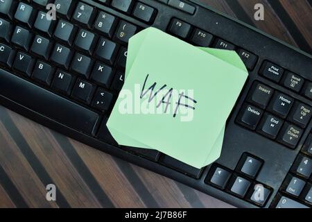 WAF - Web Application Firewall write on sticky notes isolated on Wooden Table. Stock Photo