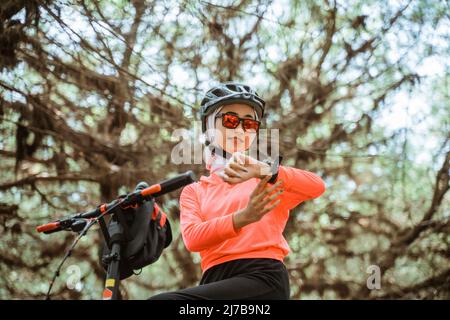 close up of woman looking at watch while cycling Stock Photo