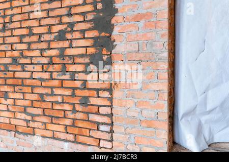 The secret room in the wall is bricked up. Bunker in a private house. Freshly laid red ceramic brick wall Stock Photo