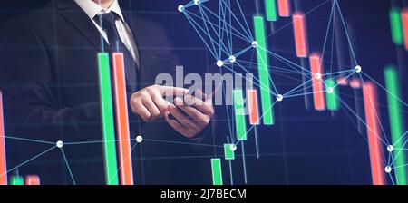 Man using smartphone with graphs analysis candle line and foreign currency rate on bokeh colors light. Manager analyzing investment statistics and ind Stock Photo
