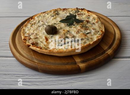 Delicious Quiche Lorraine on wooden plate with olive and mint Stock Photo