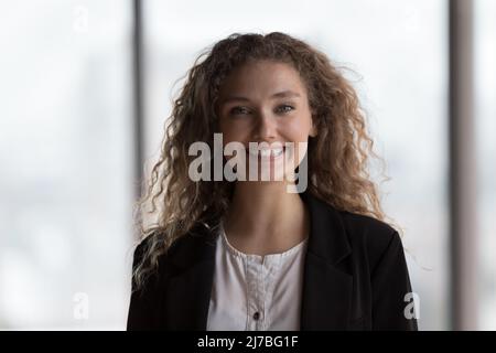 Happy young intern girl looking at camera, smiling, getting job Stock Photo