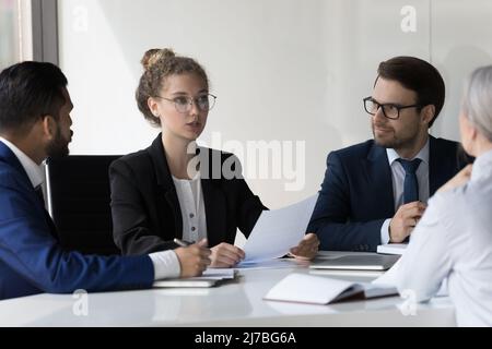 Serious young business professional woman speaking at corporate meeting Stock Photo