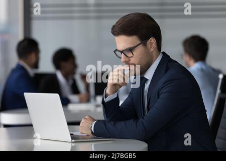 Focused business professional man in glasses working at laptop Stock Photo
