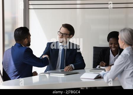 Happy confident business partners shaking hands on meeting Stock Photo