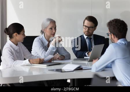 Diverse recruit team meeting, talking to job candidate for interview Stock Photo