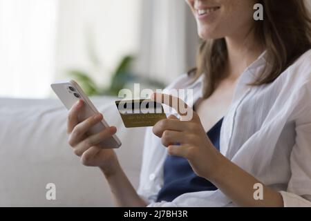 Hands of positive smiling millennial girl paying on Internet stores Stock Photo