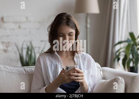 Happy focused on smartphone girl receiving message with good news Stock Photo