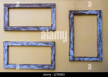 Three old wooden frames on stucco wall, close up Stock Photo