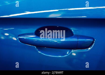 Painted handle of a blue car with metallic reflections Stock Photo
