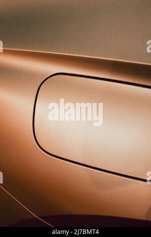Detail of the fuel tank entry on a golden car with metallic reflections and a square shape Stock Photo