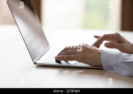Hands of middle aged business woman typing on laptop keyboard Stock Photo