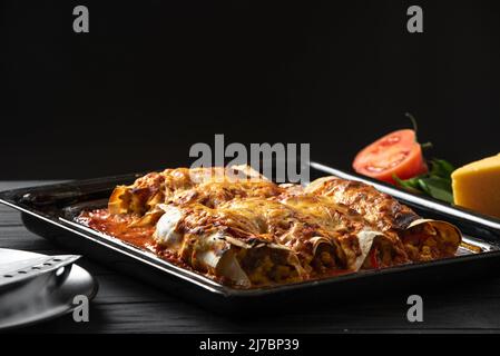 Latino American Food. Enchiladas cooked and standing on a black background Stock Photo