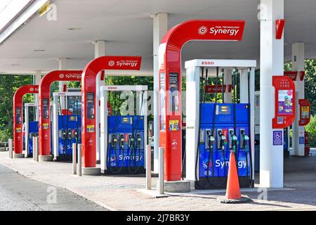 Row of four double sided Esso Synergy brand multiple choice petrol diesel vehicle fuel filling pumps on motorway service station area Essex England UK