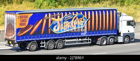 Side view hgv white lorry truck long articulated trailer food business graphic advertising McVitie's Jaffa Cakes on side curtain driving UK motorway Stock Photo