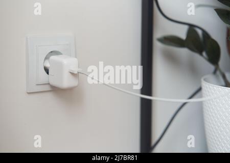 The telephone socket is plugged into the socket. Charge your phone, tablet. Stock Photo