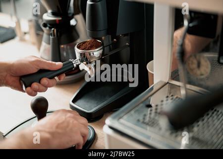 barista holding tamper near portafilter with grinded coffee, espresso, manual  press Stock Photo by LightFieldStudios