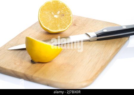 Sliced fresh lemon over chopping board on white background Stock Photo