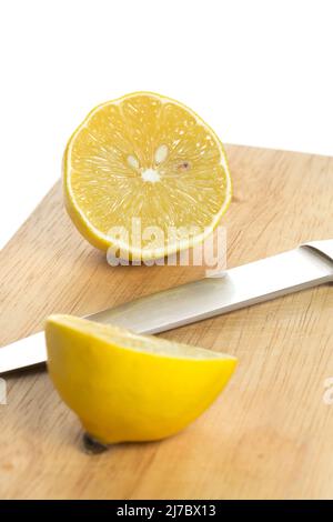 Sliced fresh lemon over chopping board on white background Stock Photo