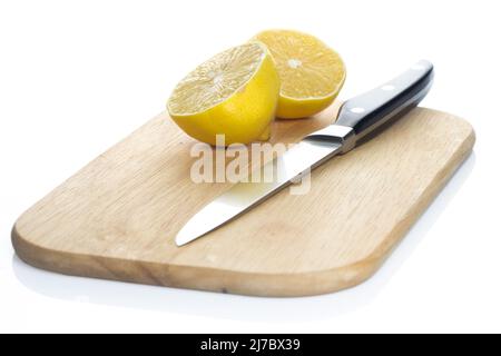 Sliced fresh lemon over chopping board on white background Stock Photo