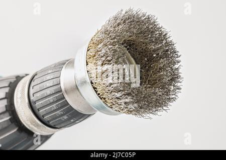 Hand drill with round steel brush on white background Stock Photo