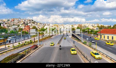 Panorama of Piraeus near Athens, Greece, Europe. Taxi cars move on city road, panoramic view of highway. Cityscape of Piraeus with trams and railway. Stock Photo
