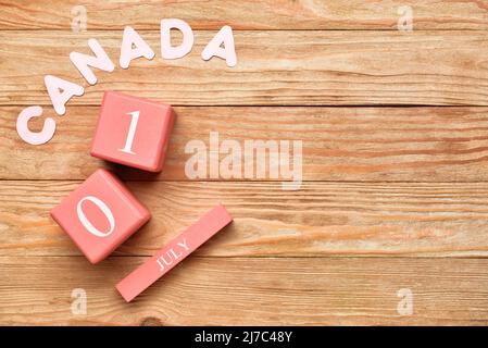 Word CANADA and cube calendar with date JULY 1 on wooden background. Happy Canada Day Stock Photo