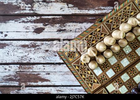 Top view of a chess game on old peeled of colored wooden table Stock Photo