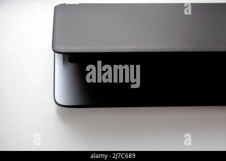 Half closed slate grey laptop on white background close-up Stock Photo
