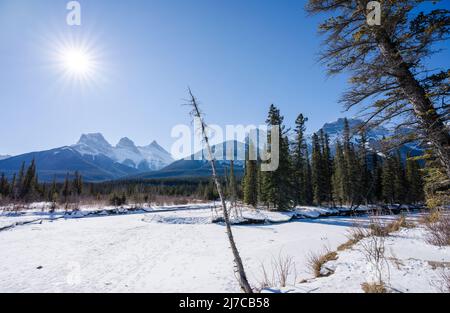 Snow capped Three Sisters ridge and Mount Lawrence Grassi mountain range during winter. Canadian Rockies beautiful scenery. Canmore, Alberta, Canada. Stock Photo