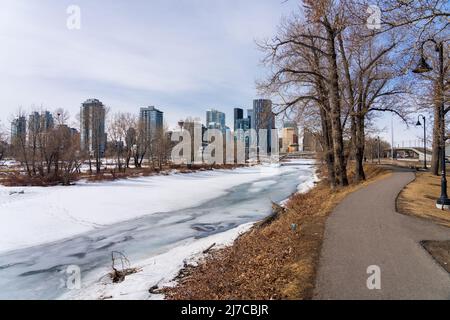 Calgary, AB, Canada - March 14 2022 : Bow River Pathway during winter. Frozen Bow River, St. Patrick's Island Park. Downtown Calgary. Stock Photo