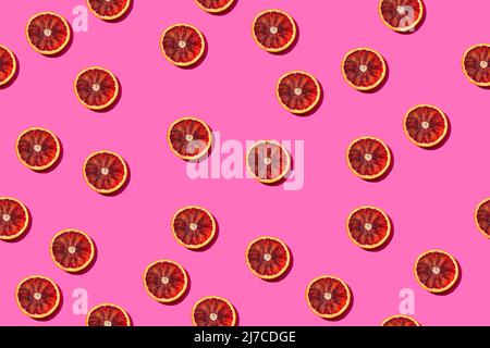 Seamless fruit pattern with round blood orange slices on a bright pink background Stock Photo
