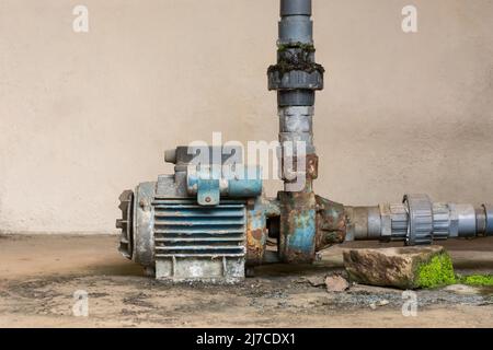 old rusty electric water pump with pvc water supply pipelines, copy space Stock Photo