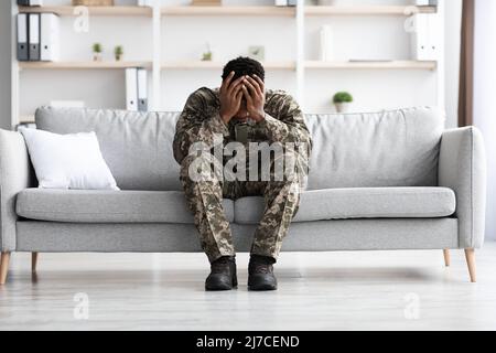 Depressed military black man covering his head with palms Stock Photo
