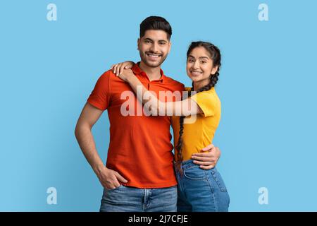 Portrait of positive young arabic couple hugging and posing at camera Stock Photo