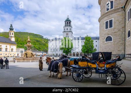 Horse drawn carriages wait to take tourists on tour of city, Residenzplatz, Salzburg, Austria. Stock Photo