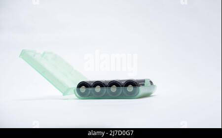 Green transluscent plastic case holding four AA type rechargeable batteries Stock Photo