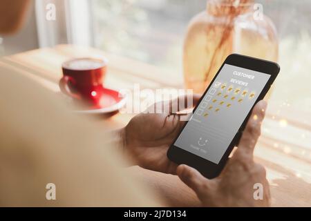 Customer service and Satisfaction concept ,Women hand hold smart phone choose the 5 star icon to give satisfaction in service. rating very impressed i Stock Photo