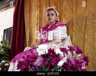 Madrid, Spain. 8th May, 2022. Portrait of the 'Maya' Rosario wearing a bow on a headband and a purple and white dress. ‘Las Mayas’ is a pagan tradition that celebrates the arrival of the Spring, worshiping young girls surrounded by flowers and offerings. This festivity has a Roman origin and is held during the first weekends of May in Madrid. © Valentin Sama-Rojo/Alamy Live News. Stock Photo