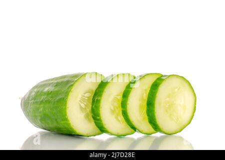 One half and three slices of juicy smooth cucumber, macro isolated on white background. Stock Photo