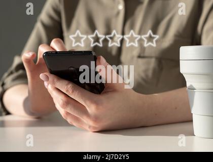 Woman using phone for rating of service, smartphone application or product quality. Online customer satisfaction feedback. High quality photo Stock Photo