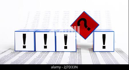 Questions and answers in business, finance. Cubes with question mark and exclamation points on statistics documents background. High quality photo Stock Photo