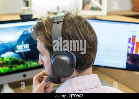 Focused thoughtful man with headphone using computer in a office Stock Photo