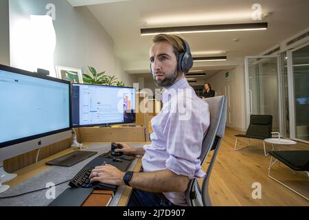 casual young man with headset using computer in a office Stock Photo