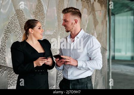 Young business colleagues talking outside the office building. Stock Photo