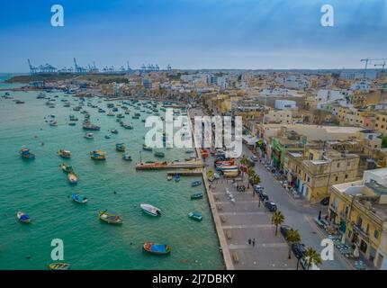 Aerial panoramic view of Marsaxlokk - small, traditional fishing village in the South Eastern Region of Malta with many colorful fisherman boats Stock Photo