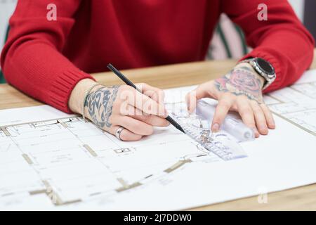 Close-up of architect drawing blueprint with pencil and ruler at table Stock Photo