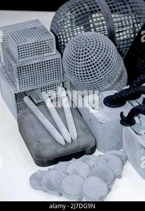 Many different models printed on 3D printer. Gray and black objects printed Stock Photo