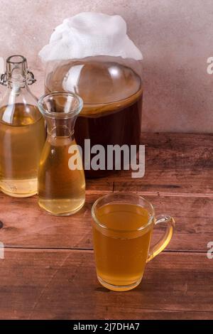 Tea mushroom in glass jars on wooden background. Preparing kombucha.  Stock Photo